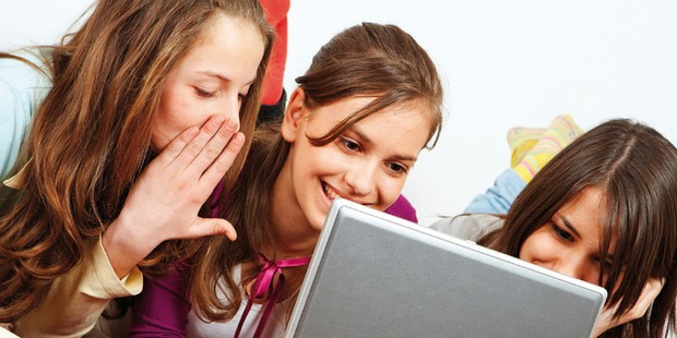 Tre flickor vid en dator