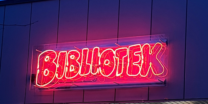 Neonbild med texten Bibliotek som sitter utanför nya biblioteket i Emmaboda