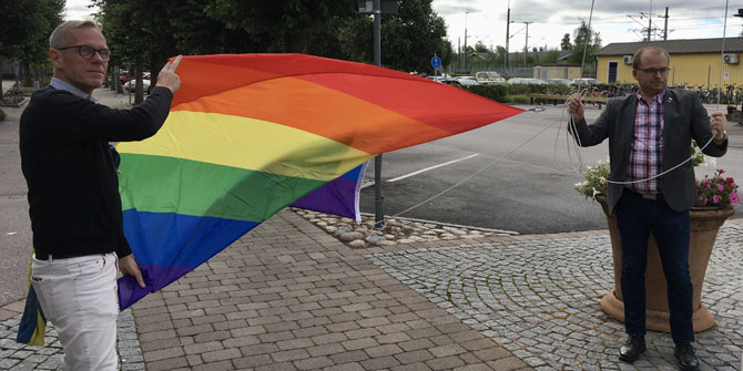 Tommy Persson, kanslichef och Johan Jonsson, kommunalråd hissar Prideflaggan.