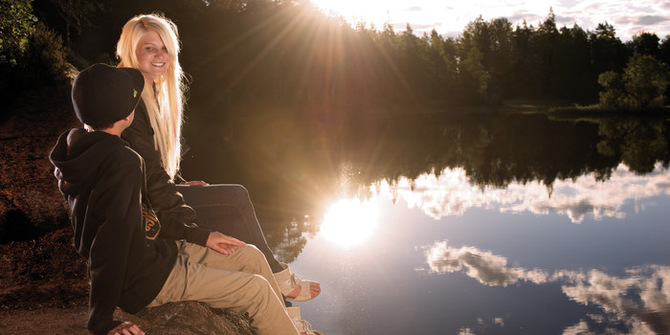 Två ungdomar som sitter vid en sjö