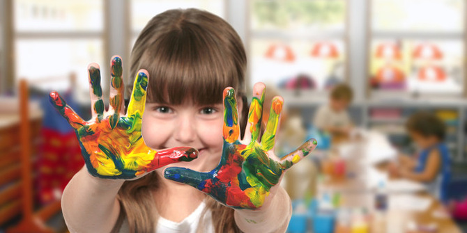 En flicka som visar upp färg på händerna
