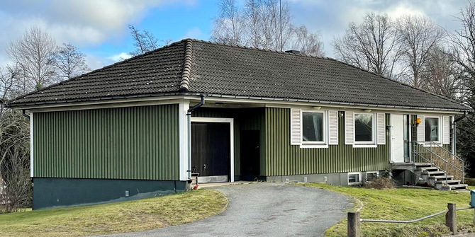 grön enplans villa med vita knutar