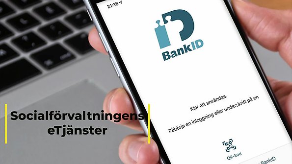 Telefon med bank-id framme i förgrunden och ett tangentbord i bakgrunden.